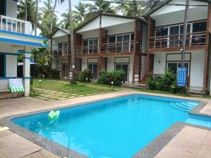 a swimming pool in front of a building at White Turtle Resort in Morjim