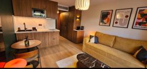 a living room with a couch and a table at Studio Golfe Juan bord de mer - parking & piscine in Vallauris