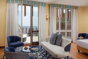 a living room with a couch and a table at UNA Hotels Capotaormina in Taormina +125 photos