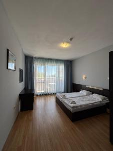 a bedroom with a bed and a large window at IZVORA APART-HOTEL Beach Front Suites in Golden Sands +167 photos