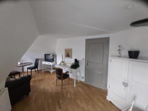 a white living room with a desk and chairs at Manoir Saint-Eloi in Noyon +5 photos
