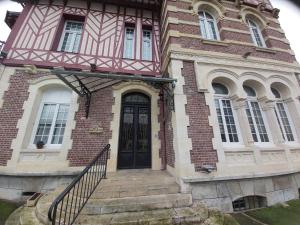 a house with a black door and stairs in front at Manoir Saint-Eloi in Noyon