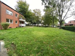 a large grassy yard next to a brick building at GM Zimmervermietung in Hamburg