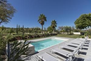 a swimming pool with lounge chairs and a swimming pool at Villa Isabelle by Algarve Holidays - Loule in Loulé