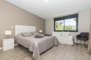 a white bedroom with a bed and a chair at Villa Isabelle by Algarve Holidays - Loule in Loulé +28 photos