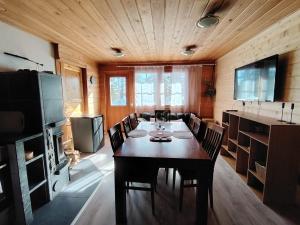 ein Esszimmer mit Tisch, Stühlen und Fernseher in der Unterkunft Metsäkoti in Saariselkä
