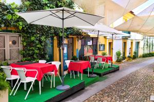 a group of tables and chairs with an umbrella at 4U Alojamento - Terraço & Varanda in Abrantes