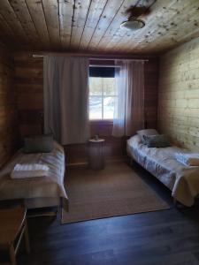 ein Zimmer mit zwei Betten und einem Fenster in der Unterkunft Metsäkoti in Saariselkä