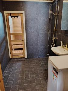 ein Badezimmer mit Waschbecken, Toilette und Dusche in der Unterkunft Metsäkoti in Saariselkä + 35 Fotos
