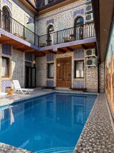 a swimming pool in front of a house at Hotel Old Heritage in Tashkent