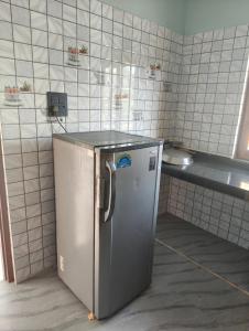 a small refrigerator in a kitchen with a counter at Rawat ji Homestay in Rāmnagar