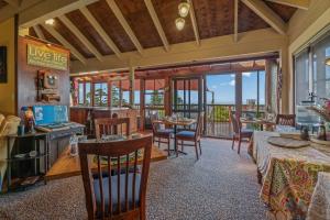 a living room with tables and chairs and windows at Tamborine Mountain Bed and Breakfast in Mount Tamborine