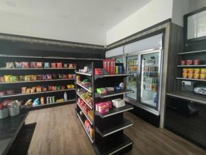 a grocery store aisle with an open refrigerator at Get Inn Hotel at 1 Capital Holdings in Gua Sai