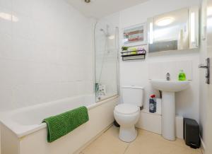 a white bathroom with a toilet and a sink at Group-Friendly Flat - 3 Beds, a Sofa Bed & Parking in Andover