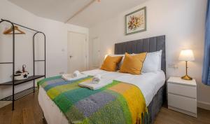 a bedroom with a large bed with towels on it at Group-Friendly Flat - 3 Beds, a Sofa Bed & Parking in Andover