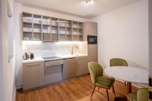 a kitchen with a table and chairs and a table and a counter at Galant Apartments in Cluj-Napoca