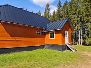 an orange house with a black roof at Nature Reserve Hideaway in Nohipalu