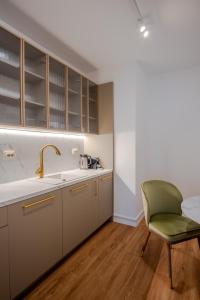 a kitchen with a sink and a green chair at Galant Apartments in Cluj-Napoca +121 photos