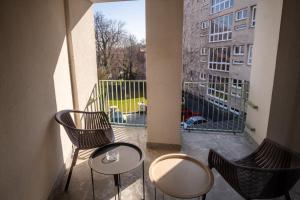 a balcony with two chairs and a table and a window at Galant Apartments in Cluj-Napoca