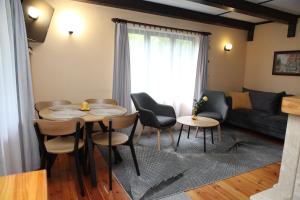 a living room with a table and chairs and a couch at Domek Mazury u Basi in Jerutki