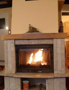 a fireplace in a living room with a fire in it at Domek Mazury u Basi in Jerutki +15 photos