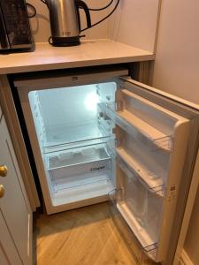 an empty refrigerator with its door open in a kitchen at Sunny Garden WFH Retreat with Private Entrance and Parking near NEC BHX JLR in Solihull