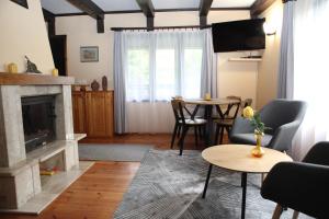 a living room with a fireplace and a table at Domek Mazury u Basi in Jerutki