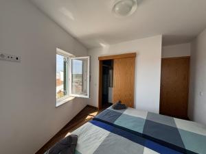 a bedroom with a bed and two windows at Casa da Boa Vista in Bordeira