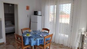 a dining room table with a blue table cloth on it at Appartement balcon proche mer in Saint Pierre La Mer