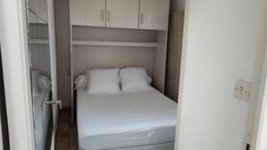 a small bed with two pillows in a small room at Appartement balcon proche mer in Saint Pierre La Mer