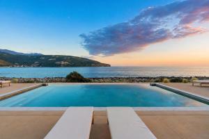 a swimming pool with a view of the ocean at Alkyon SeaSide Studios in Neo Itilo