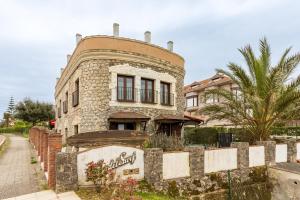 an old stone house with a fence in front of it at Casa Del Surf Somo in Somo
