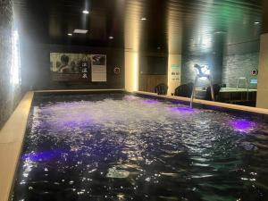 a pool of water with purple lights in a building at HOTEL LiVEMAX Toyooka in Toyooka