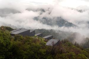 a group of buildings on a hill in the clouds at ARTOTEL Cabin Bromo in Bromo