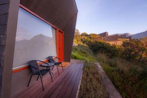a balcony with two chairs and a large window at ARTOTEL Cabin Bromo in Bromo