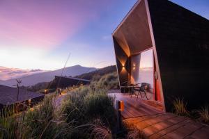 a house with a deck with a view of the mountains at ARTOTEL Cabin Bromo in Bromo +38 photos