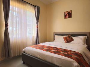 a bedroom with a bed and a large window at Larami House Narok in Narok