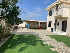 a patio with green grass next to a building at استراحة العمران in Murayjāt