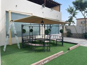 a patio with a table and chairs under a canopy at استراحة العمران in Murayjāt