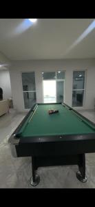 a pool table in a living room with afits at استراحة العمران in Murayjāt
