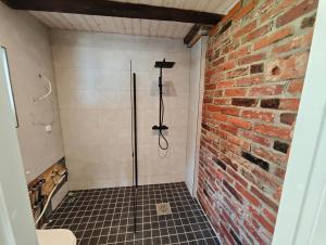 a shower in a bathroom with a brick wall at Nature Reserve Hideaway in Nohipalu