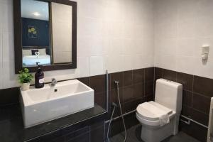 a bathroom with a sink and a toilet and a mirror at Get Inn Hotel at 1 Capital Holdings in Gua Sai