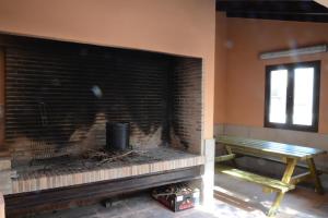 a brick fireplace in a room with a bench at Casa Domingo in Manzanera