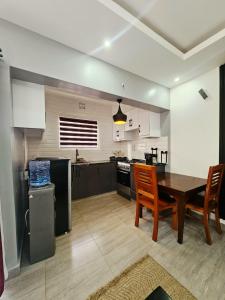 a kitchen and dining room with a table and chairs at Larami House Narok in Narok