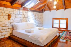 a bedroom with a bed in a stone wall at Anhel Hotel in Berat