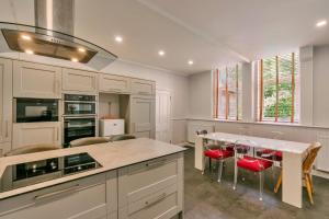 a kitchen with white cabinets and a table with red chairs at Finest Retreats - Wallingbrook Lodge in Chulmleigh