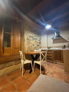 a kitchen with a wooden table and two chairs at APARTAMENTOS La Colmena APT - 1 - AT-CC-00248 in Gata +13 photos