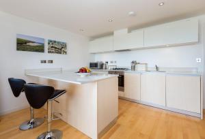 a kitchen with white cabinets and a counter top at 11 Zinc in Newquay in Newquay +10 photos