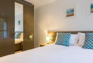 a bedroom with a large white bed with blue pillows at 11 Zinc in Newquay in Newquay