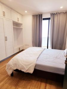 a bedroom with a large white bed with a window at Premium 2 Bedroom Apartment Near Airport in Muscat